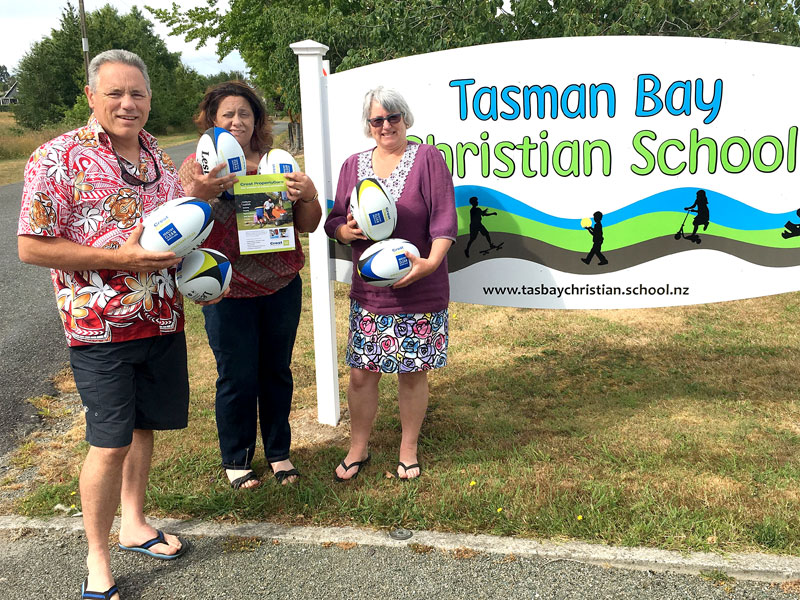 Craig Starrenburg and Judy-Anne Sunby receive the rugby balls from Barbara de Vries, CrestClean’s Nelson Regional Manager. 