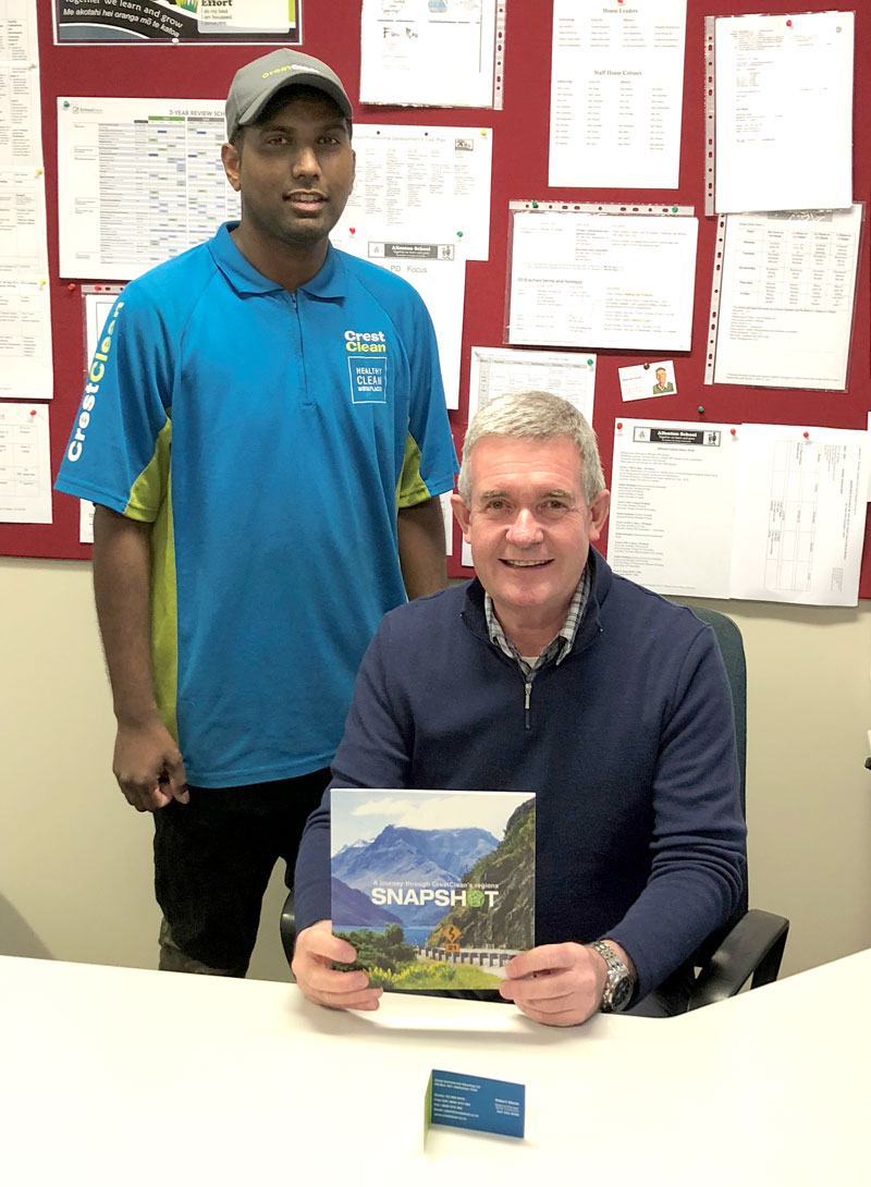 Bruce Tilby receives a copy of CrestClean’s anniversary book from Ashitosh Prasad. 