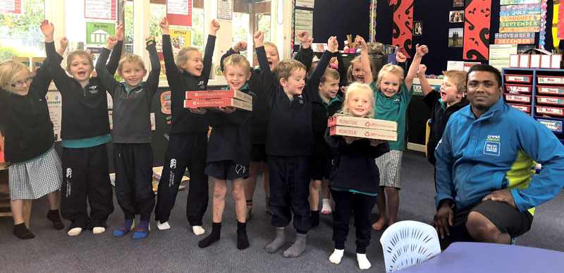 CrestClean business owner Krishna Kumar hands out pizza to children in Willoby Class at Longbeach School in Ashburton. 