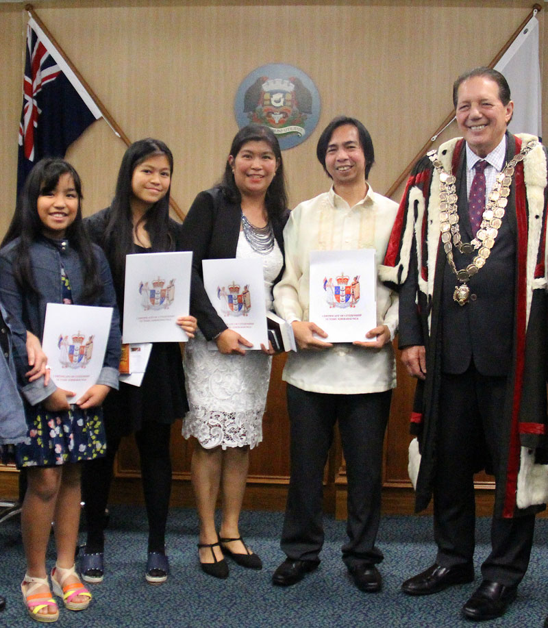 The family receive their New Zealand Citizenship Certificates from Invercargill Mayor Tim Shadbolt. Photo: Invercargill City Council