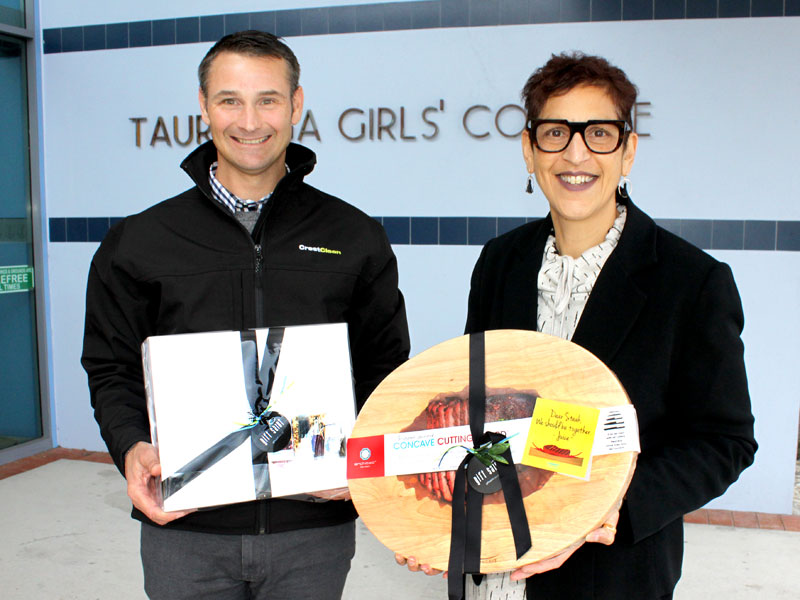 Tauranga Girls' College Principal Tara Kanji receives a gift pack and cutting board from Jan Lichtwark, CrestClean’s Tauranga Regional Manager. 